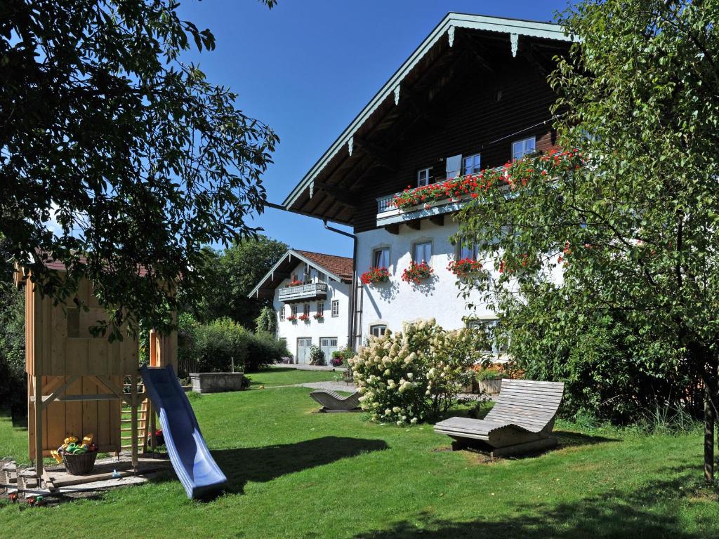 una casa con parque infantil y un tobogán en el patio en Ferienhof Moyer, en Höslwang