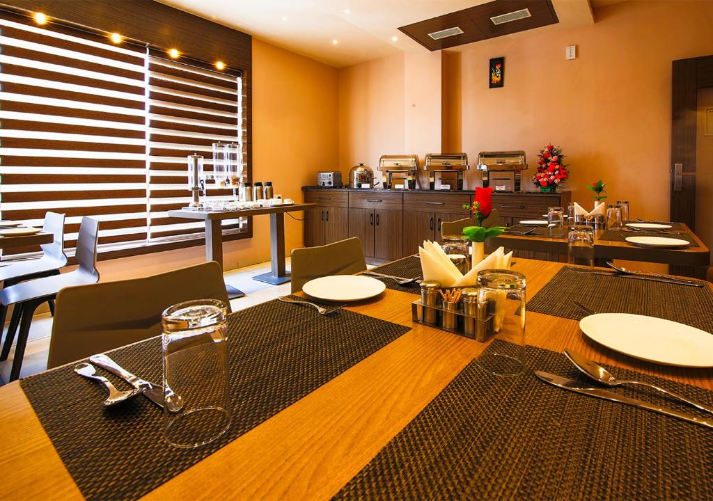 une salle à manger avec une table et des chaises ainsi qu'une cuisine dans l'établissement Aloka Stay Inn, à Vellore