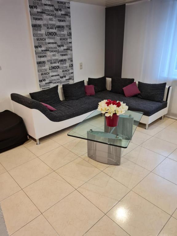 uma sala de estar com um sofá e uma mesa com flores em Ni Va Li em Bretzenheim