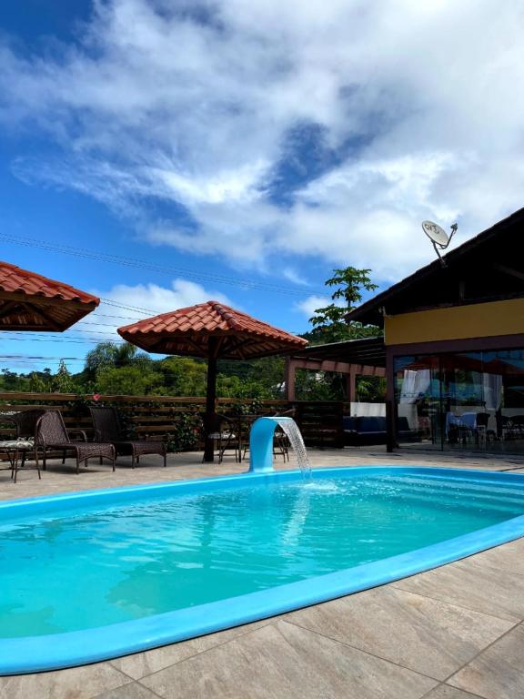 a swimming pool with a water fountain at Pousada Praia de Bombinhas in Bombinhas