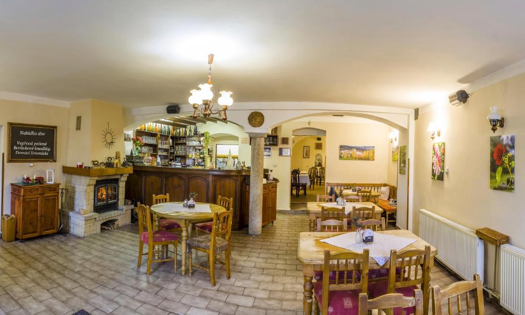 restauracja ze stołami i krzesłami oraz kominkiem w obiekcie Penzion U Candru w mieście Vyšší Brod
