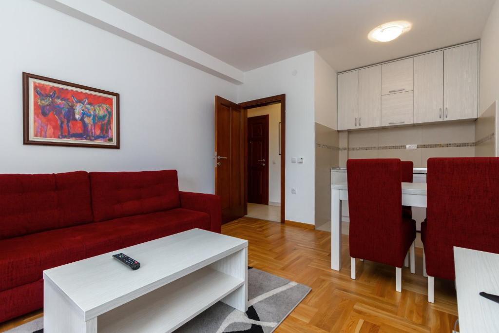 uma sala de estar com um sofá vermelho e uma mesa em Apartman Nađa em Zlatibor