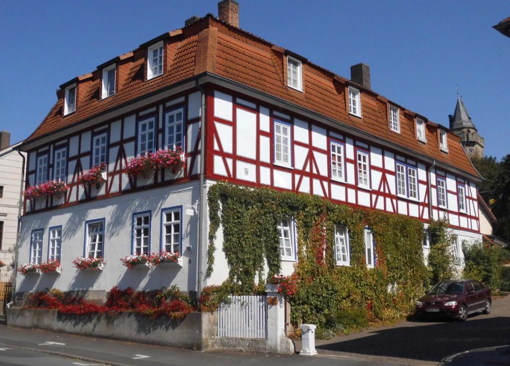 czerwono-biały budynek z bluszczem w obiekcie Ferienwohnung Wacker, Apartments und Zimmer w mieście Züschen