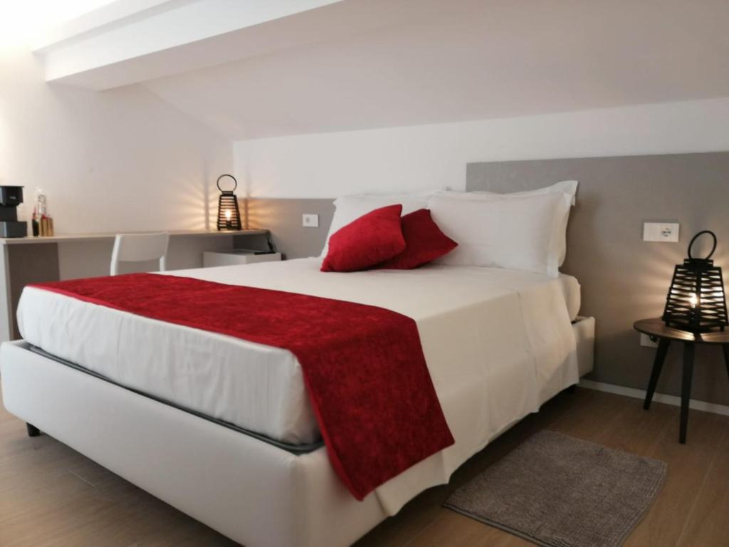 a bedroom with a large white bed with red pillows at La Mansardina in Riccione