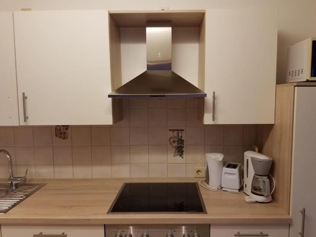 a kitchen with white cabinets and a stove top oven at Ferienwohnung Wacker, Apartments und Zimmer in Züschen
