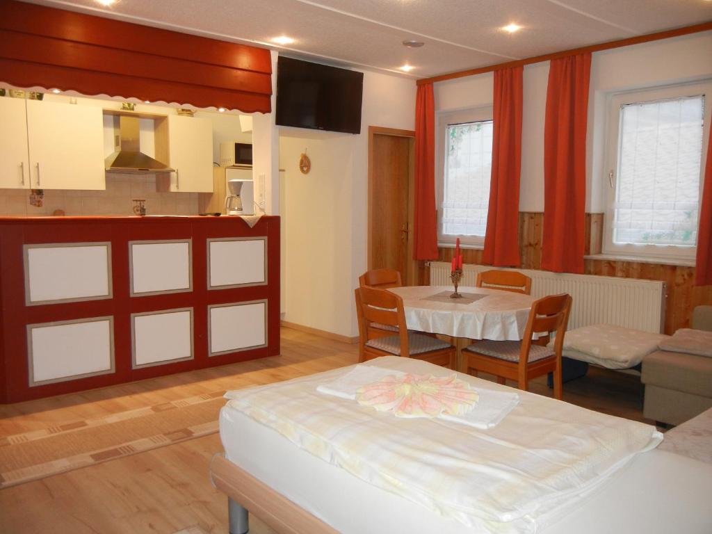 a room with a bed and a table and a kitchen at Ferienwohnung Wacker, Apartments und Zimmer in Züschen