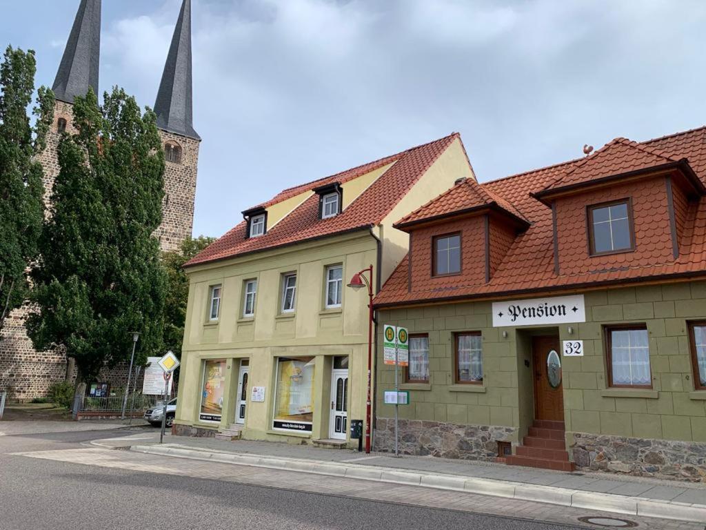 un bâtiment sur le côté d'une rue avec une église dans l'établissement Pension32, à Burg bei Magdeburg