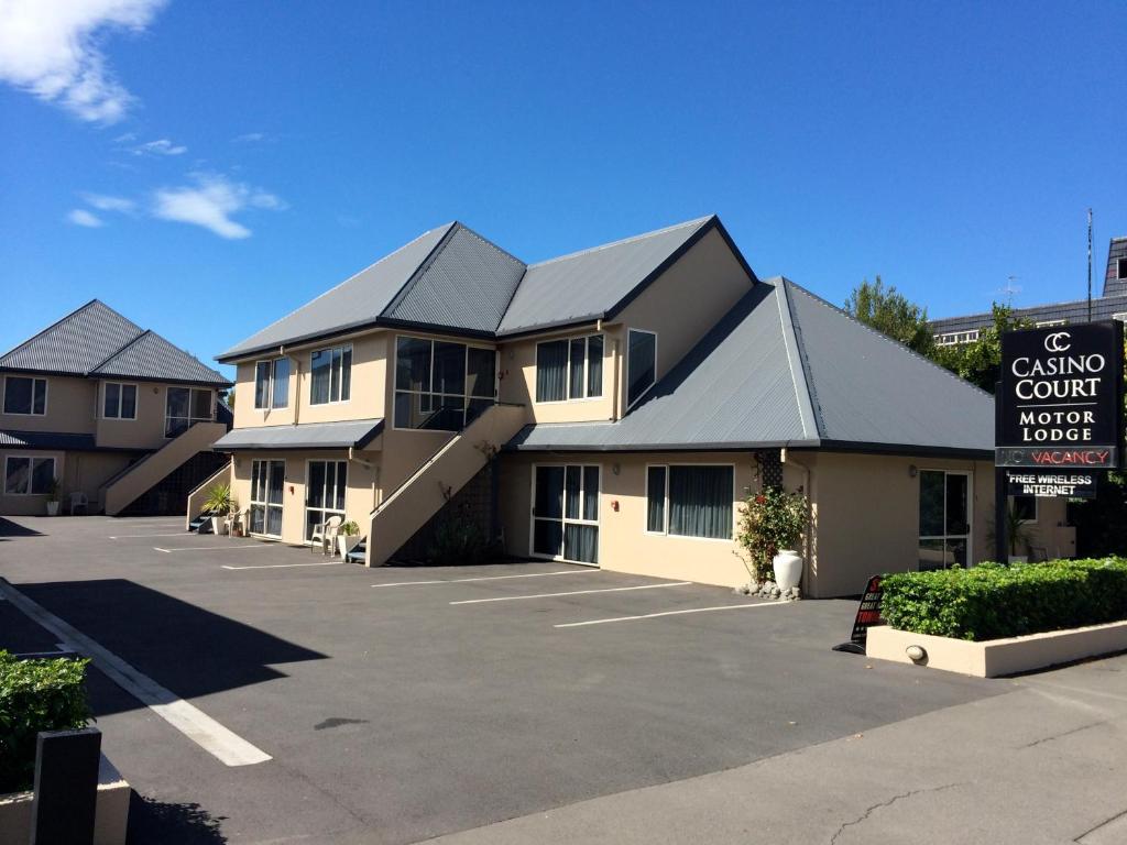 un edificio con aparcamiento frente a un motel en Casino Court Motor Lodge, en Christchurch