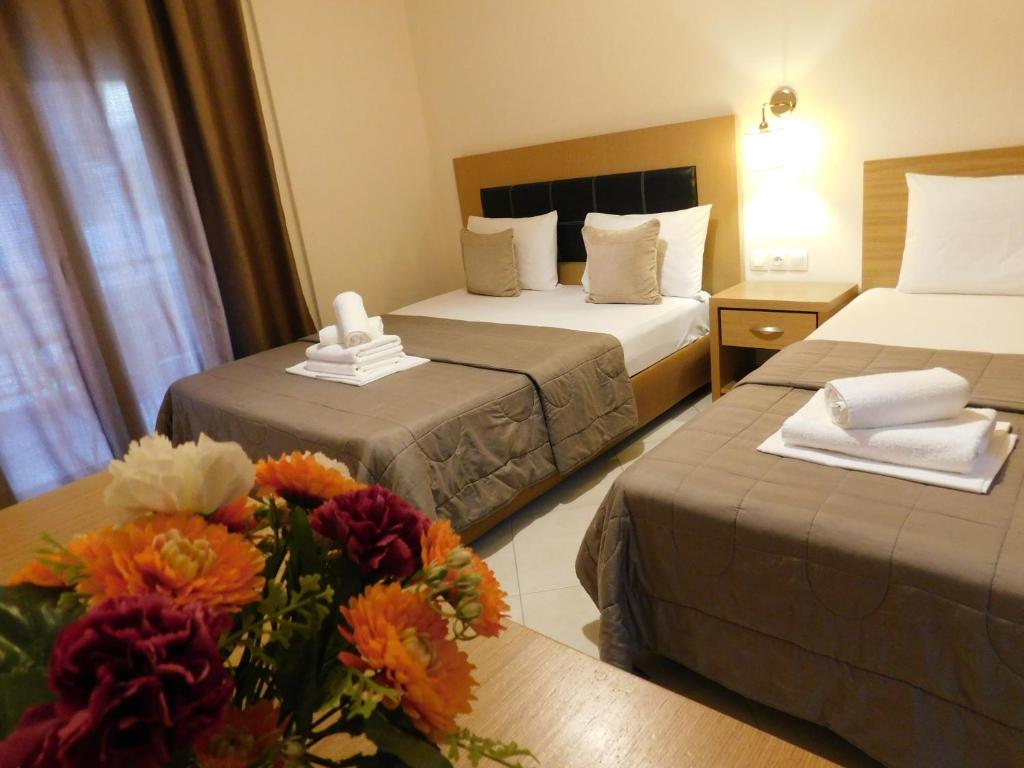 a hotel room with two beds and a bouquet of flowers at Anna house 3 in Sarti