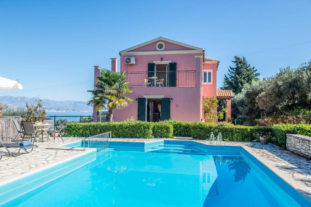 a villa with a swimming pool in front of a house at Villa Lenio Perithia Loutses in Perítheia