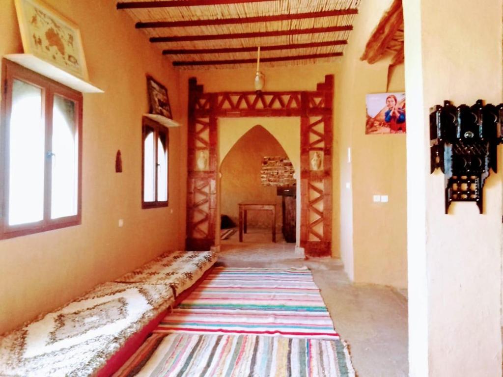 a hallway of a house with a large rug on the floor at Riad Marhaba Merzane in Merzane