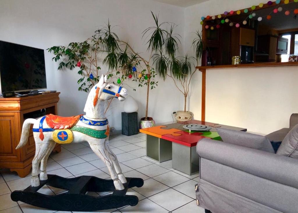 venez visitez calais في كاليه: غرفة معيشة مع خيل ألعاب وسط غرفة