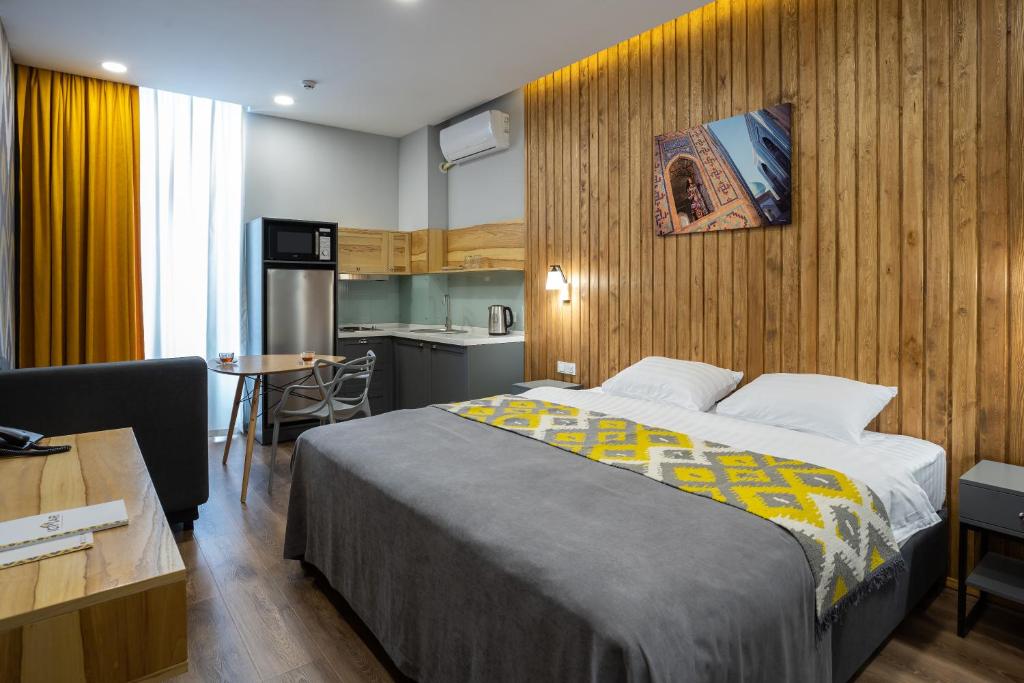 een hotelkamer met een bed en een keuken bij IGMAR Apart Hotel in Tasjkent