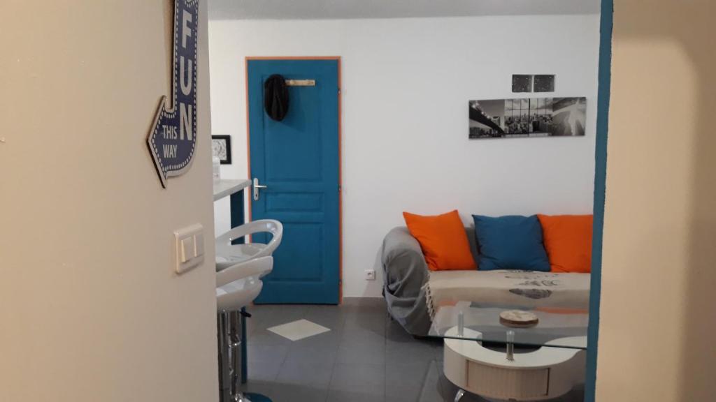 - un salon avec un canapé et une porte bleue dans l'établissement Pause Appart 40 m2 avec cour privative - Spacieux & Confortable, à Saint-Ambroix