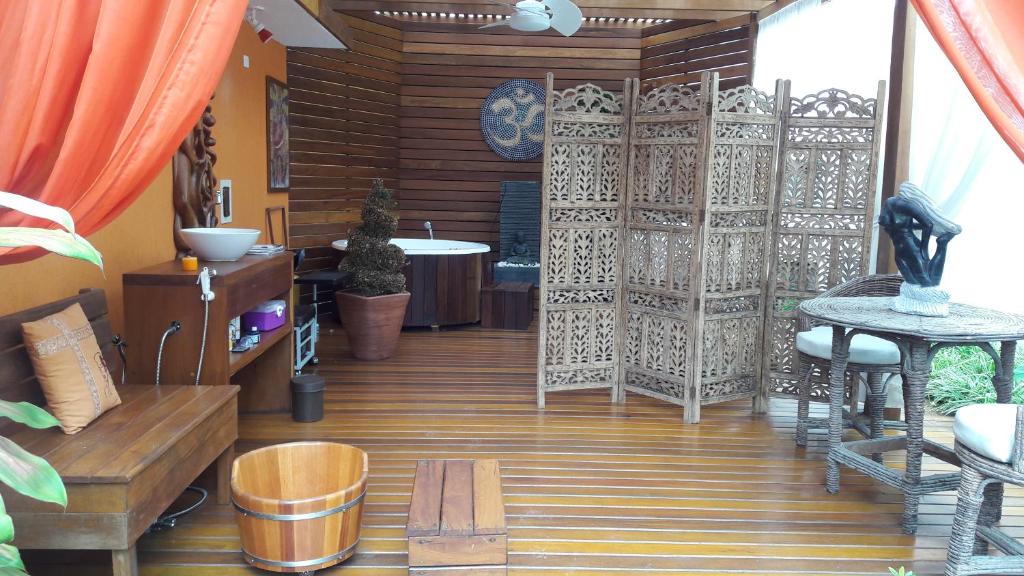 a room with a wooden floor with a gate and a tub at Pousada Mari in Guarujá