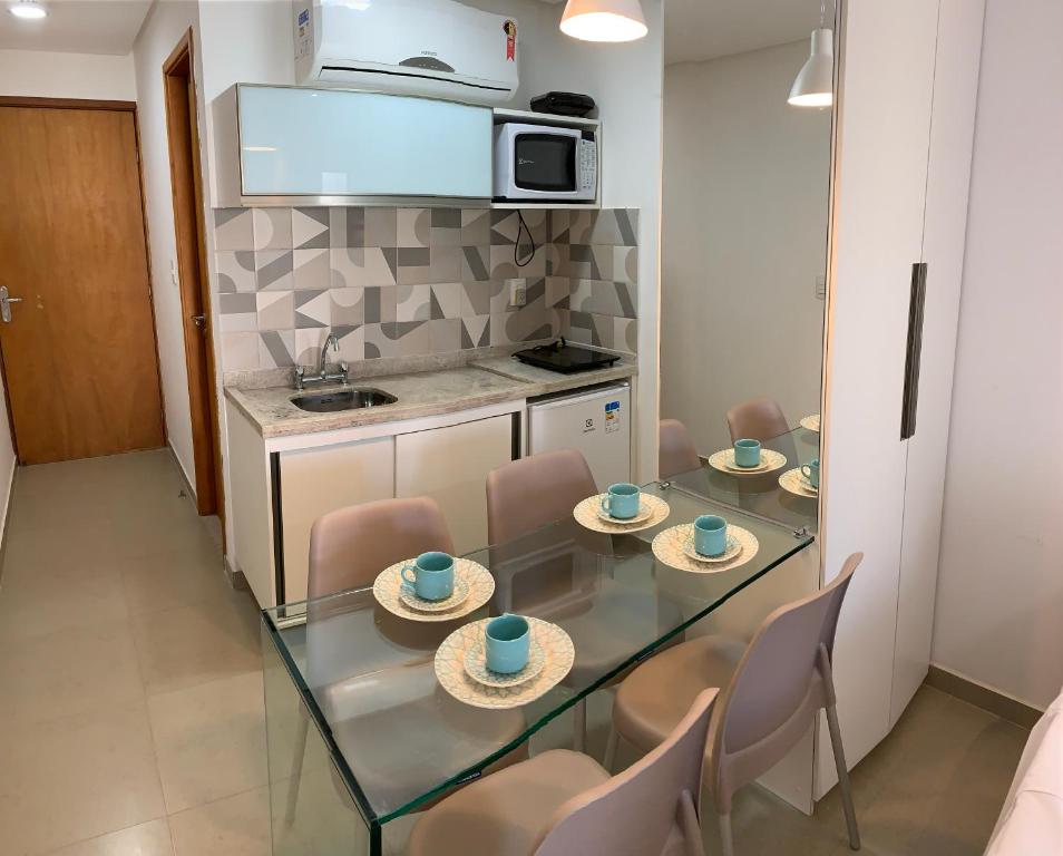 a dining room with a glass table and chairs at Manawa Flat A14 in Porto De Galinhas