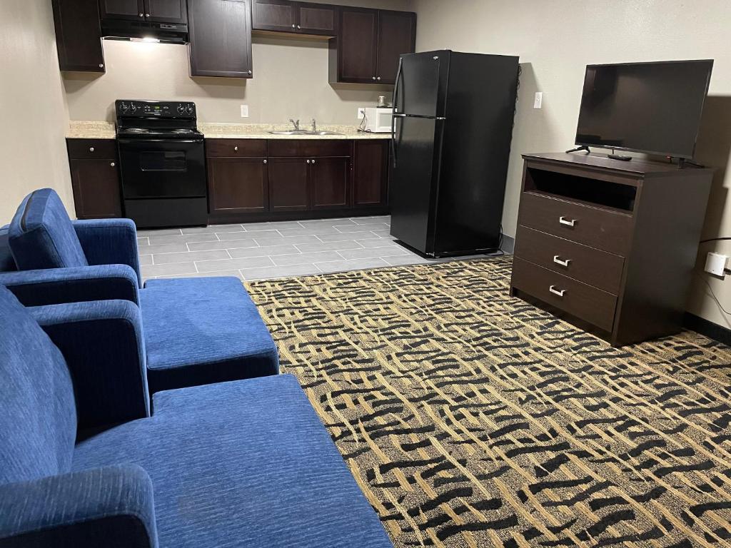 a kitchen with a blue couch and a black refrigerator at Days Inn & Suites by Wyndham Collierville Germantown Area in Collierville