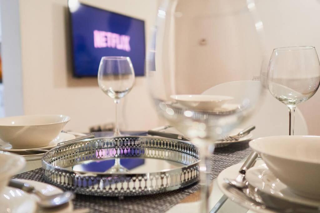 una mesa con copas de vino y platos en ella en Luxury Two Bed City Apartment -The Hub, en Milton Keynes