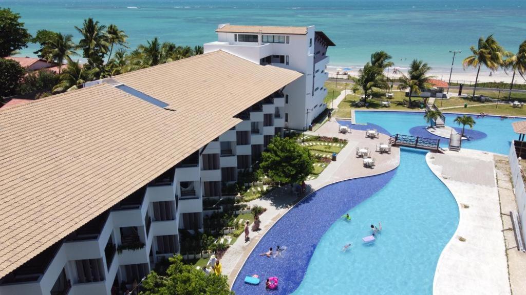einen Luftblick auf ein Resort mit einem Pool in der Unterkunft Maui Beach Residence - Beira Mar - Apartamento Térreo in Recife