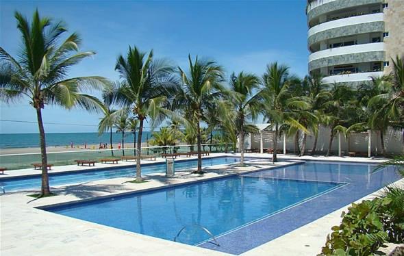 einen Pool mit Palmen und Strand in der Unterkunft Cartagena Morros playa edificio frente al mar 1 in Cartagena de Indias