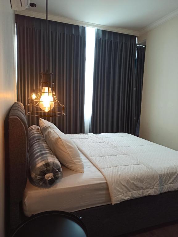 a bedroom with a bed with a light on it at Apartemen Startegis di Mega Kuningan in Jakarta