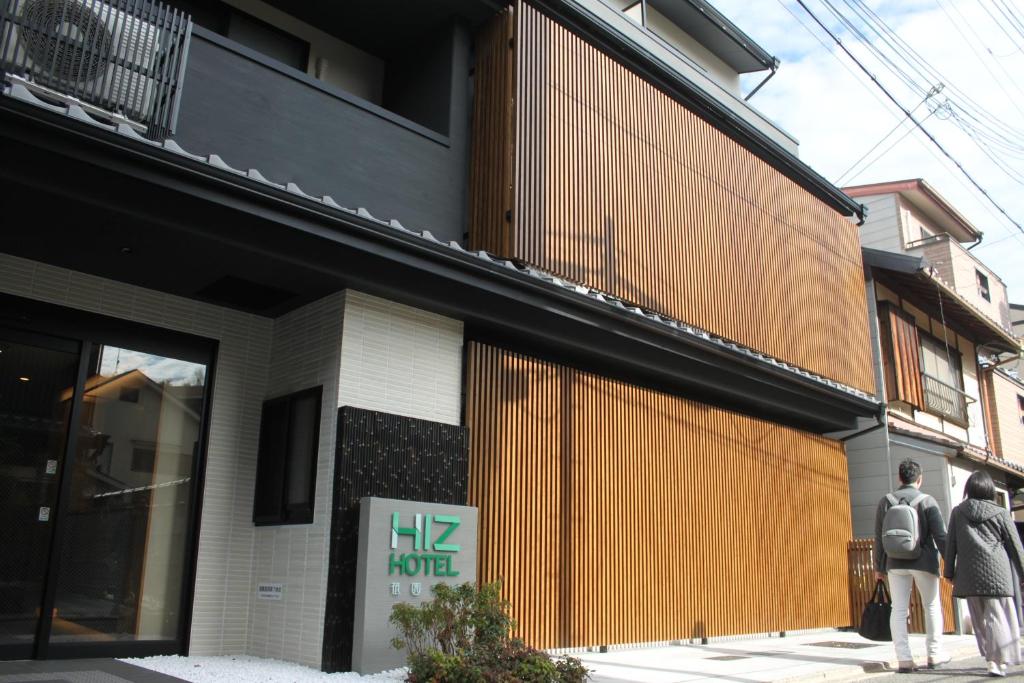 two people standing in front of a building at HIZ HOTEL Gion-Shirakawa in Kyoto