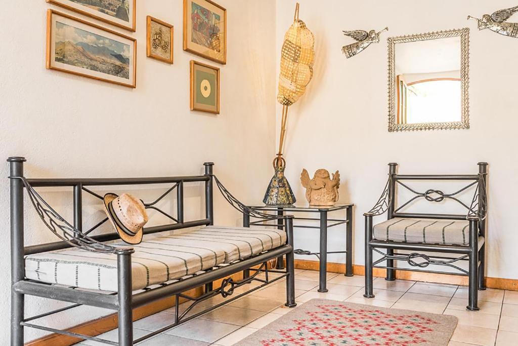 a living room with two chairs and a mirror at Posada de los Angeles in Oaxaca City