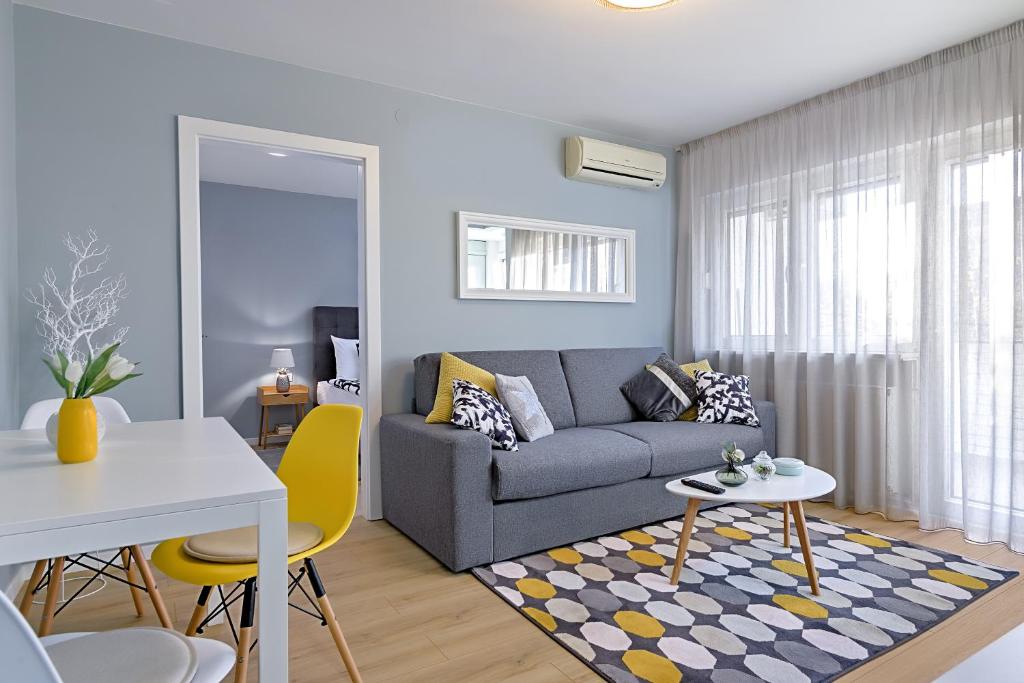 uma sala de estar com um sofá cinzento e uma mesa em Charming Place near Centre with GARAGE parking em Zagreb