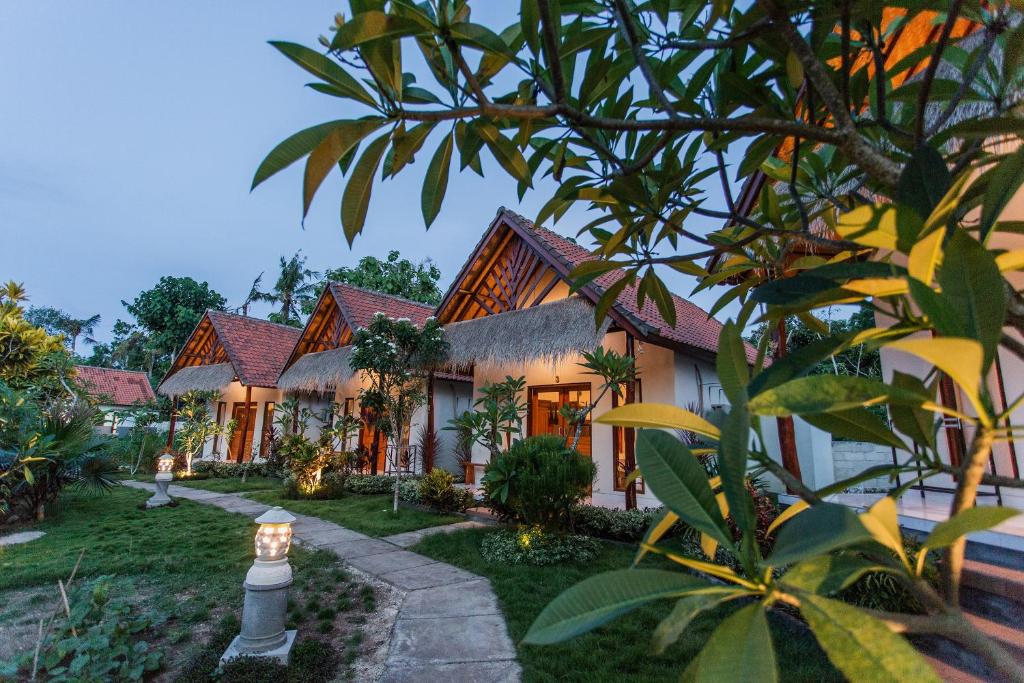 eine Außenansicht eines Hauses mit Garten in der Unterkunft Camar Cottage & Hostel in Nusa Penida