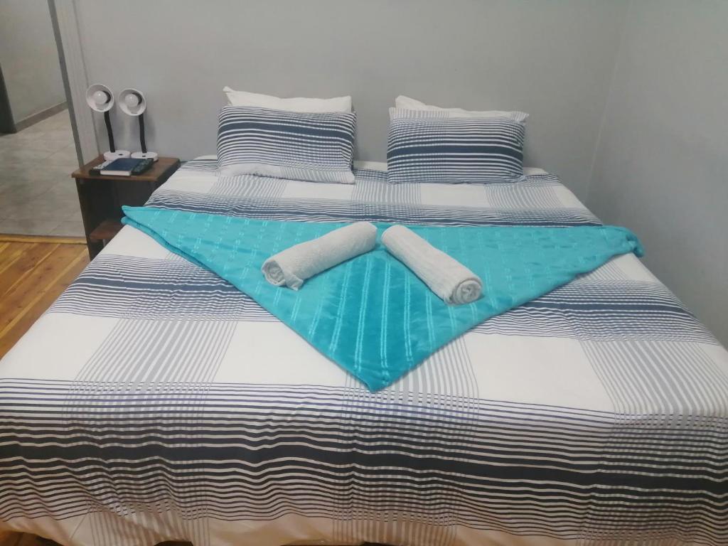 een bed met twee opgerolde handdoeken erop bij Keetmanshoop Self-catering in Keetmanshoop