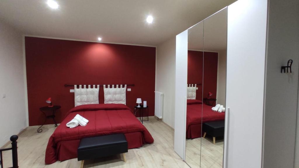 een slaapkamer met een rode muur en een rood bed bij Casa Tintilia in Isernia