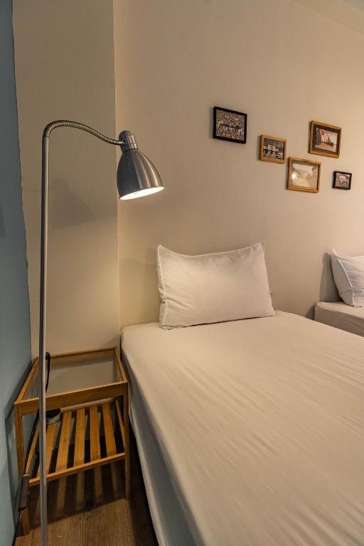 a bedroom with a bed with a lamp next to it at Cozy House Hostel in Hualien City