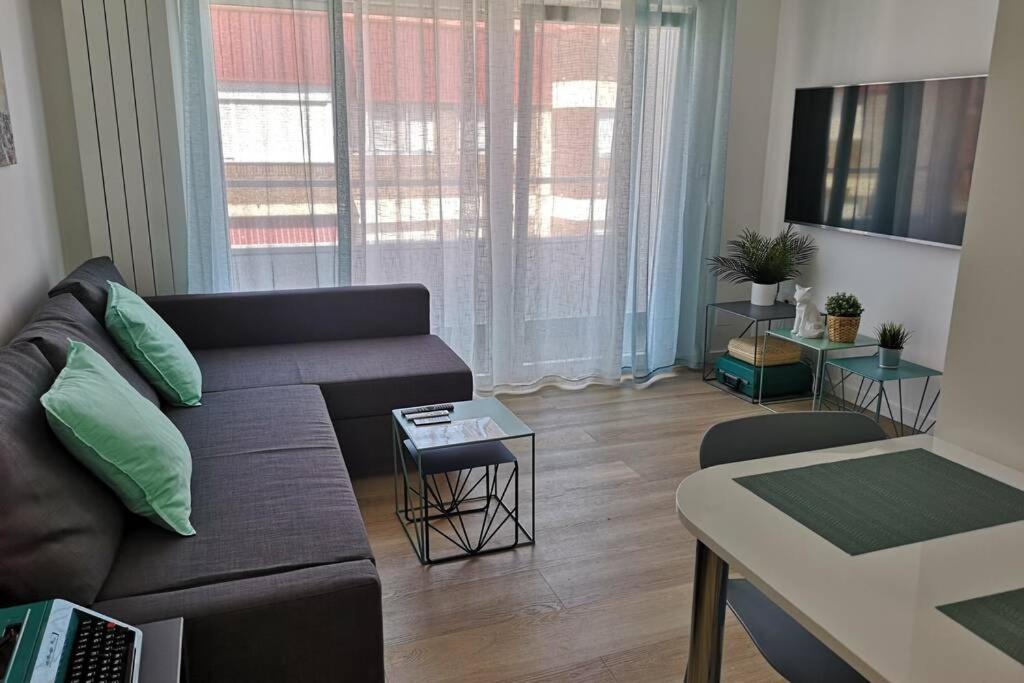 a living room with a couch and a table at Piso moderno con garaje en el centro de Vigo in Vigo