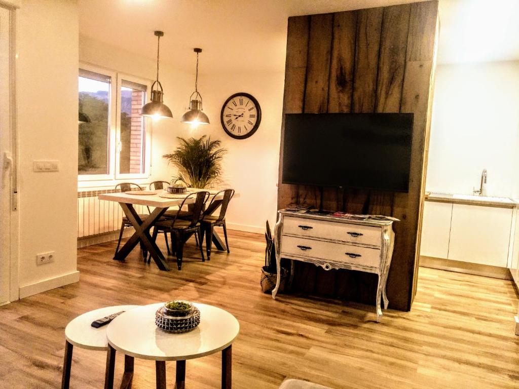 a living room with a tv and a table and a dining room at Apartamento Gaztainondoak(II)A 10min de Laguardia in Lanciego