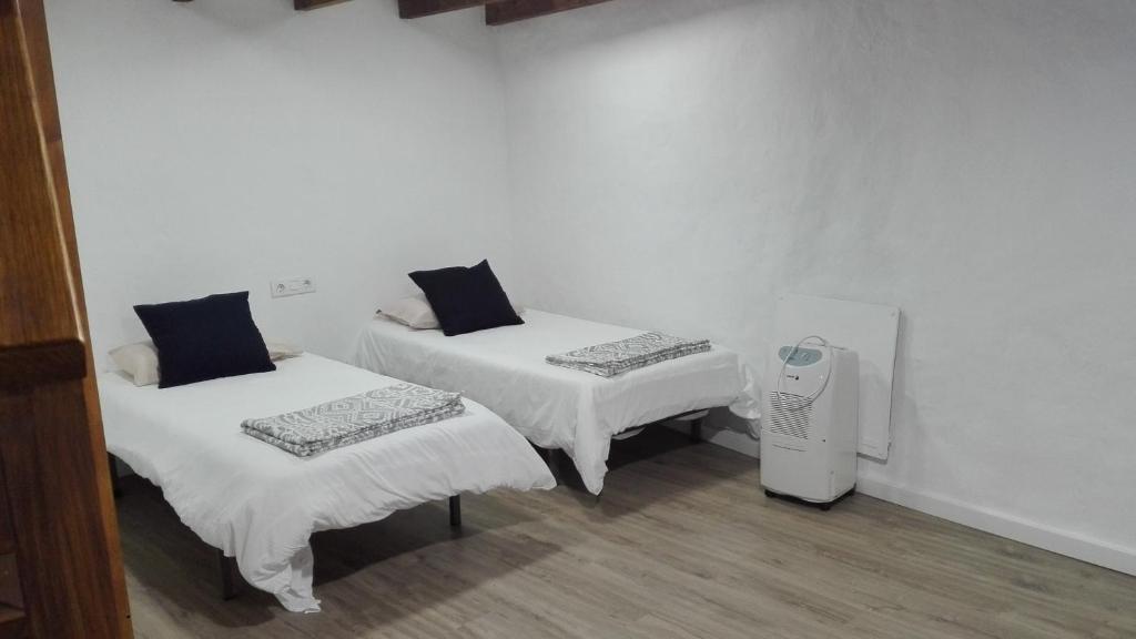 a room with two beds and a air compressor at House to relax El Tanque in Tanque