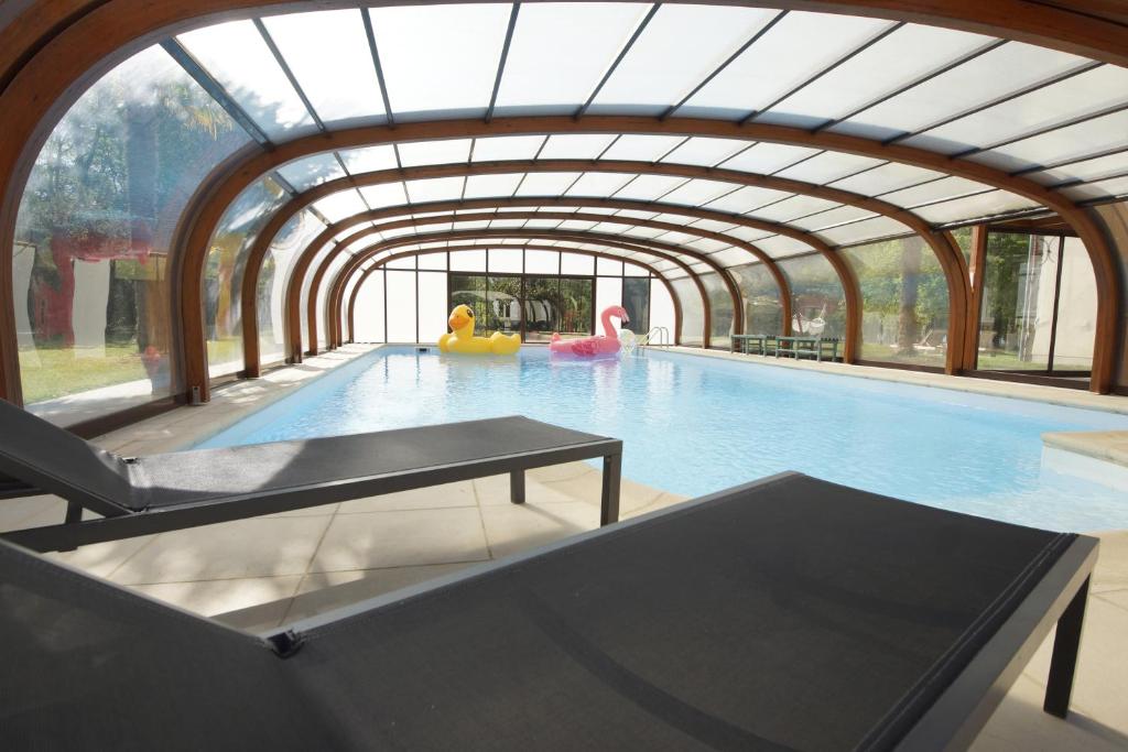 uma piscina interior com um tecto arqueado em Domaine Providence em Lassay-sur-Croisne