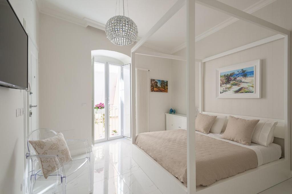 a white bedroom with a bed and a window at Porta Piccola Luxury Home in Bari