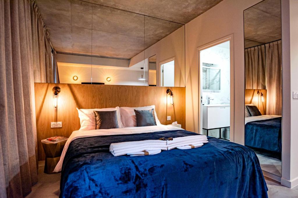 um quarto com uma cama grande e um cobertor azul em Citihome Paris em Paris