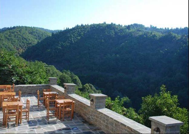a patio with tables and chairs and a view of a mountain at Hotel Dryades in Negádes