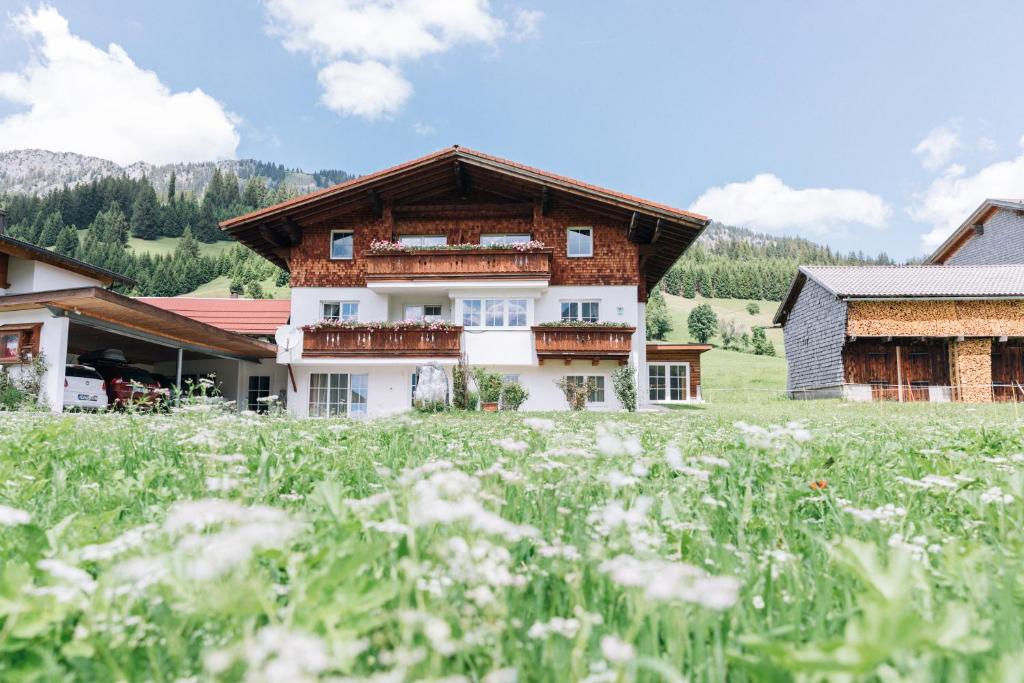 a house in the mountains with a field of flowers at Sammer's Rosenchalet in Tannheim