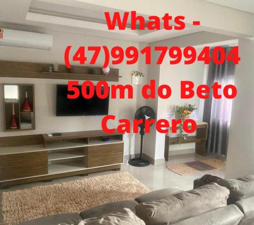 een woonkamer met een bank en een flatscreen-tv bij Casa ao lado do parque Beto carreiro da de ir a pé para o parque João carlos casas in Penha