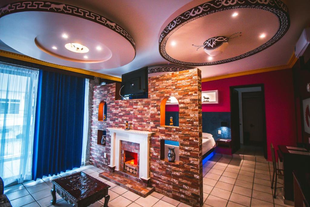 a living room with a brick fireplace with a tv at Hotel Boutique TEKALI INN in Cuetzalán del Progreso