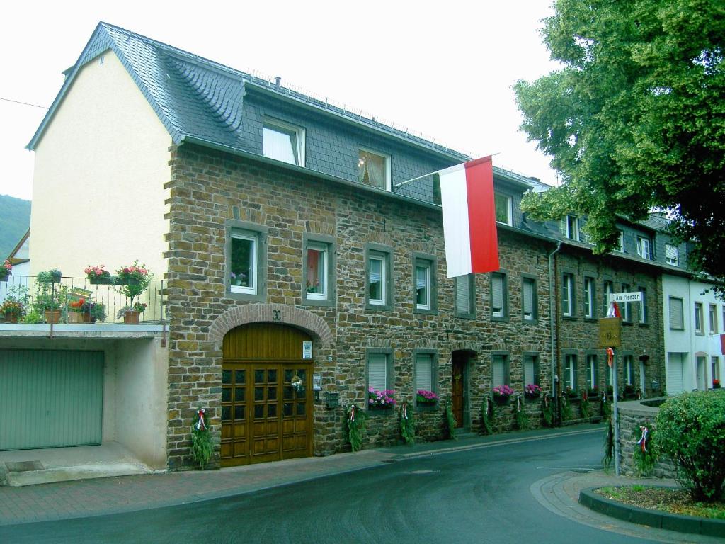 ein großes Backsteingebäude mit einer roten und weißen Flagge in der Unterkunft Ferienwohnung Hilger in Treis-Karden