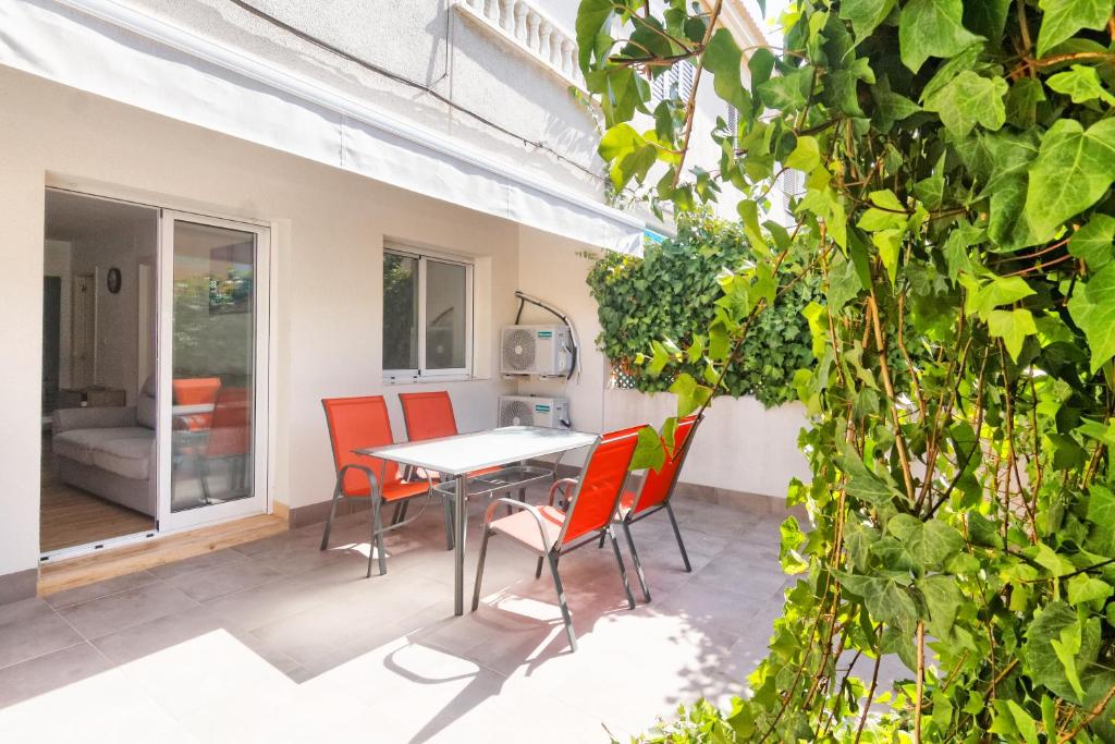 un patio con sillas naranjas y una mesa en el balcón en EL Mojon Beach Apartment, en El Mojón