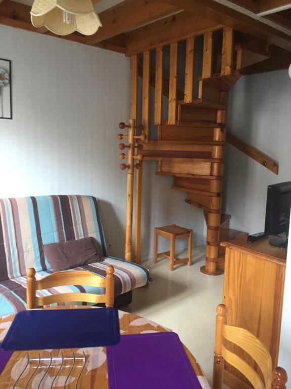 sala de estar con escalera de madera y sofá en Appartement Cauterets, en Cauterets