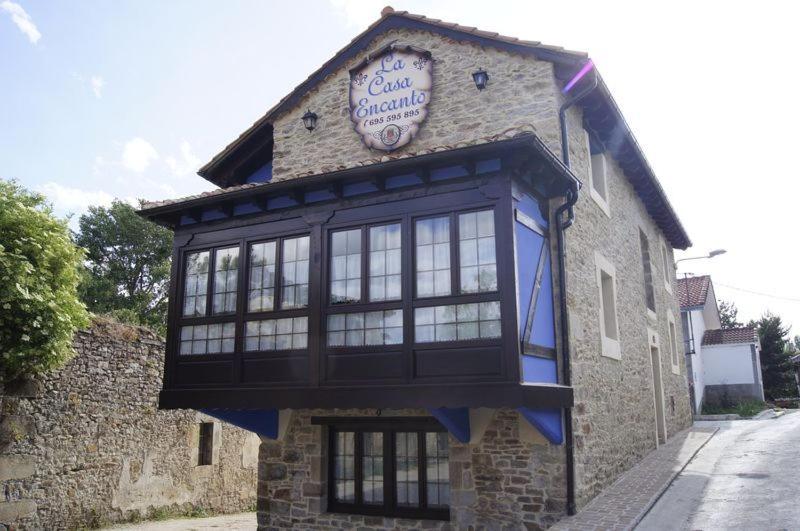 um edifício com um relógio na lateral em La Casa Encanto em Espinosa de los Monteros