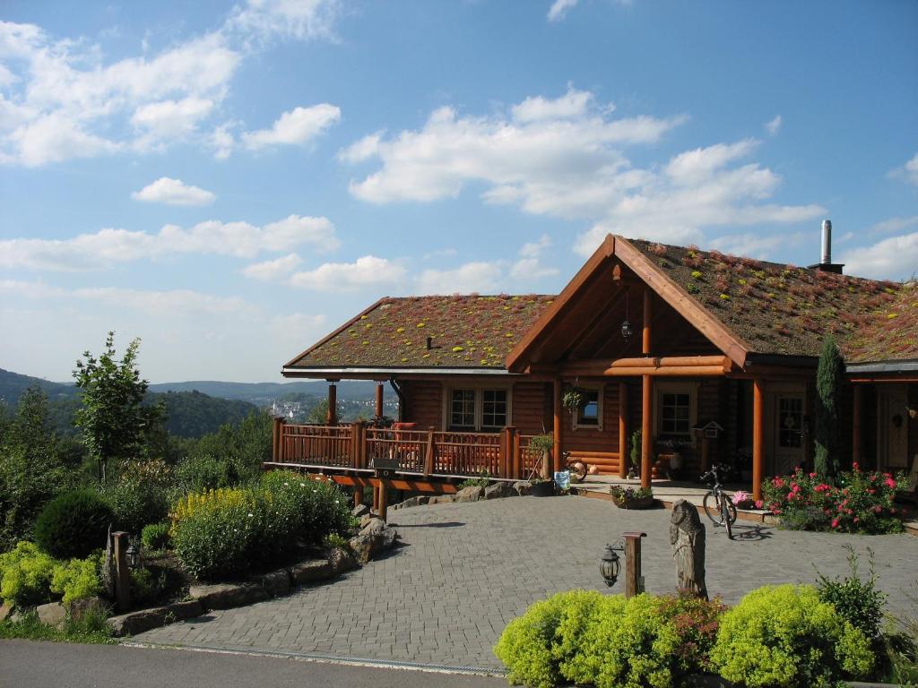 a large wooden house with a large patio at Hotelanlage Country Lodge in Arnsberg