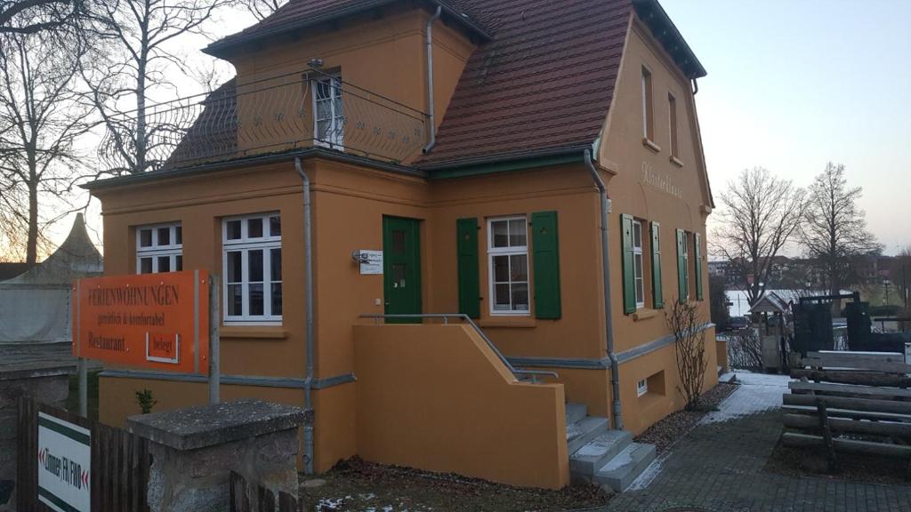 a small yellow house with a brown roof at Große Ferienwohnung Klosterklause Malchow in Malchow