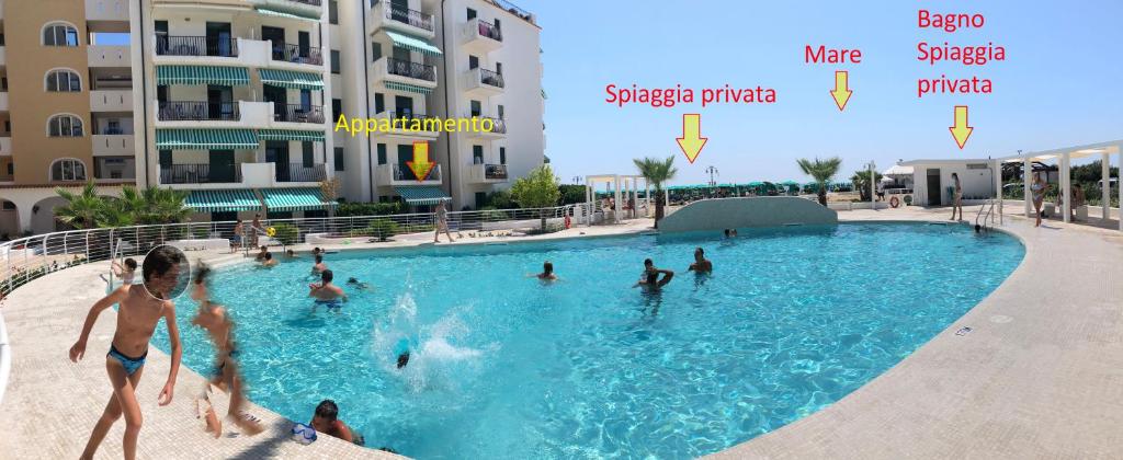 a group of people playing in a swimming pool at RESIDENCE EL PALMAR FRONTE MARE, FRONTE SPIAGGIA (5 metri), FRONTE PISCINA (4 metri) in Lido di Jesolo
