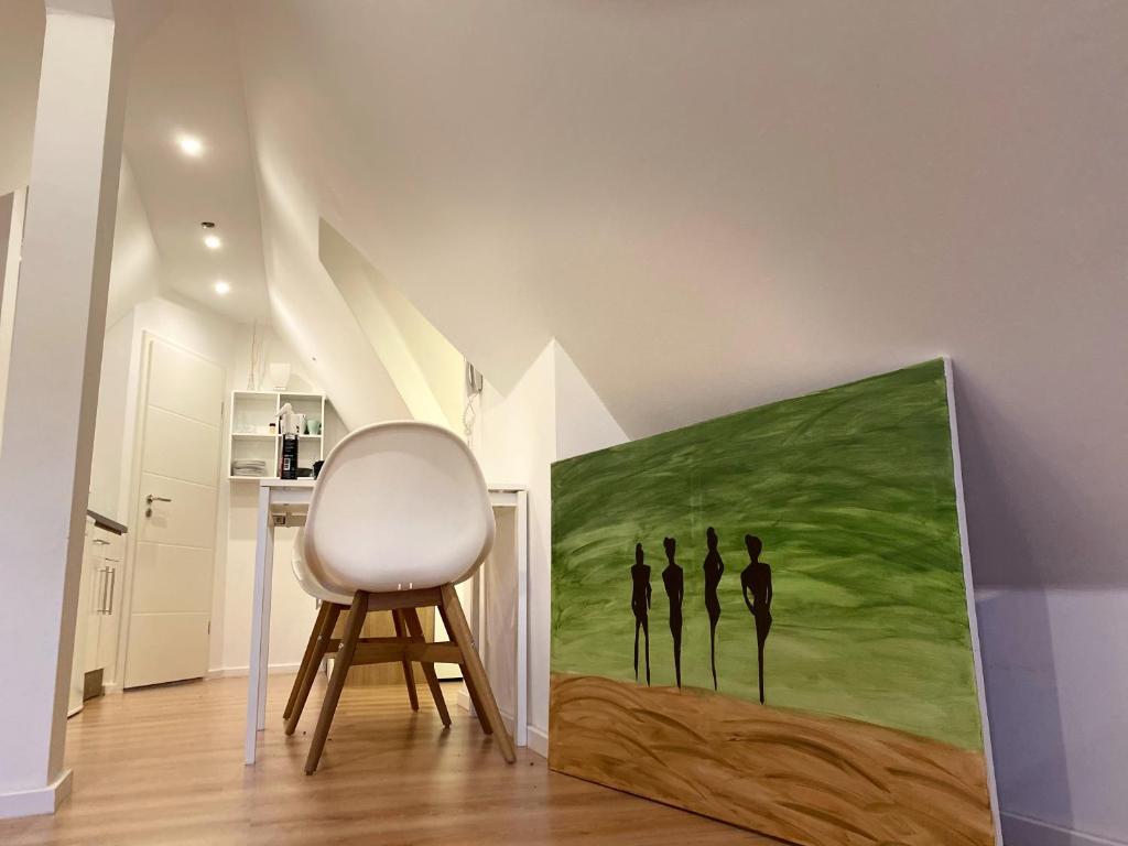 una habitación con una silla y un cuadro en la pared en City Apartment, en Lörrach
